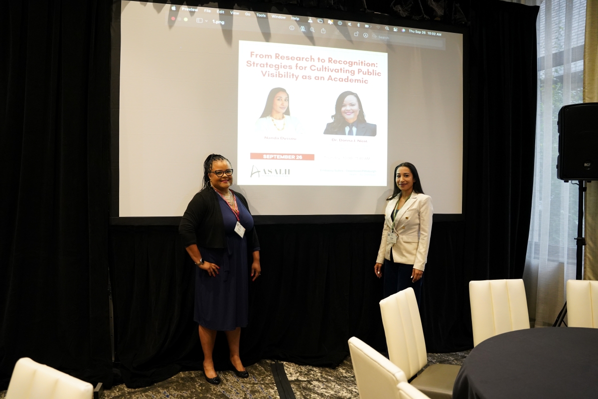 From Research to Recognition: Cultivating Public Visibility as an Academic Nanda Dyssou and Professor Donna J. Nicol standing in front of their presentation slides at the ASALH workshop ‘From Research to Recognition: Cultivating Public Visibility as an Academic’ in Pittsburgh.